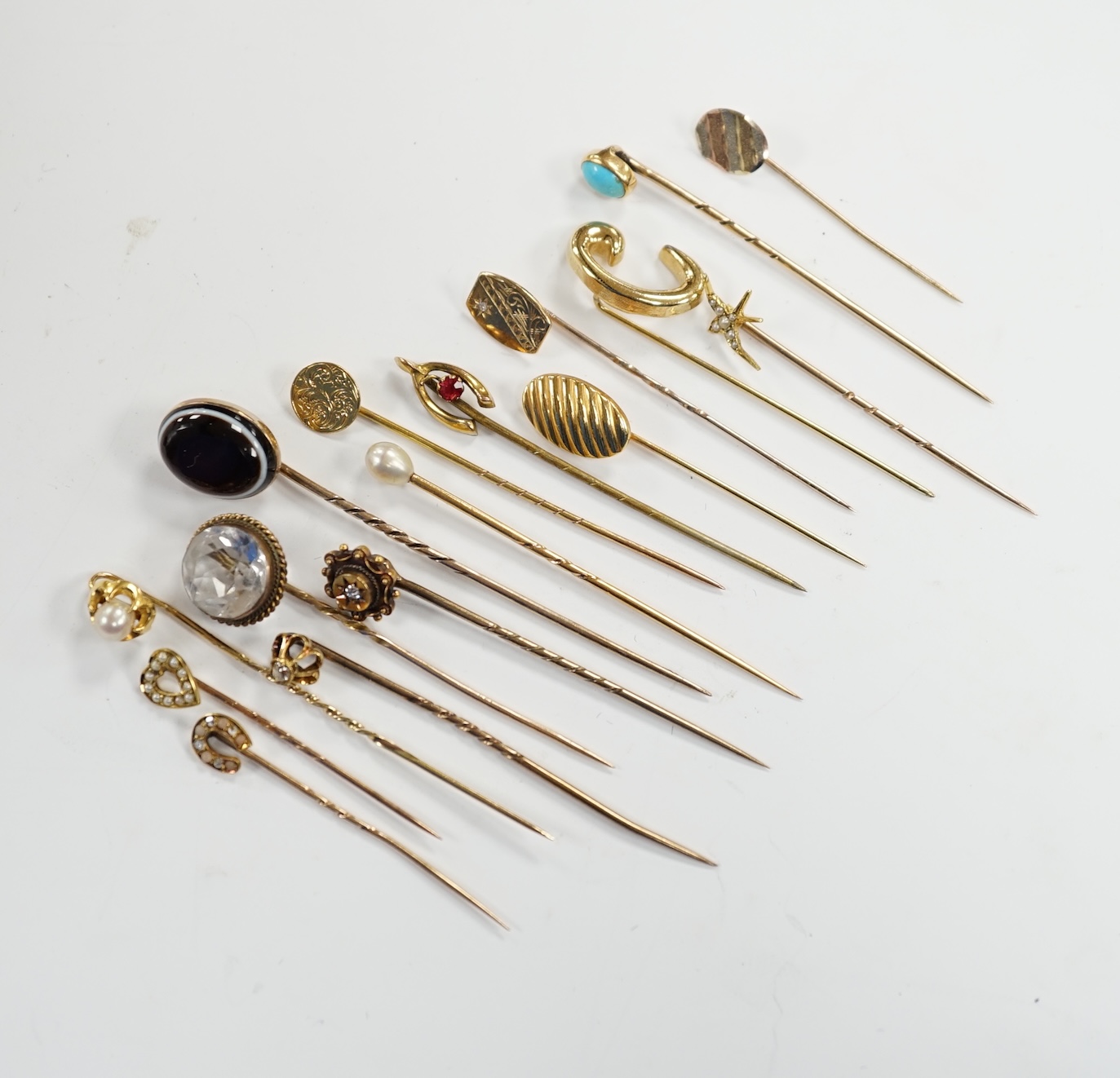 Fifteen assorted mainly early 20th century yellow metal and gem set stick pins, including diamond, seed pearl and banded agate, gross weight 23.1 grams.